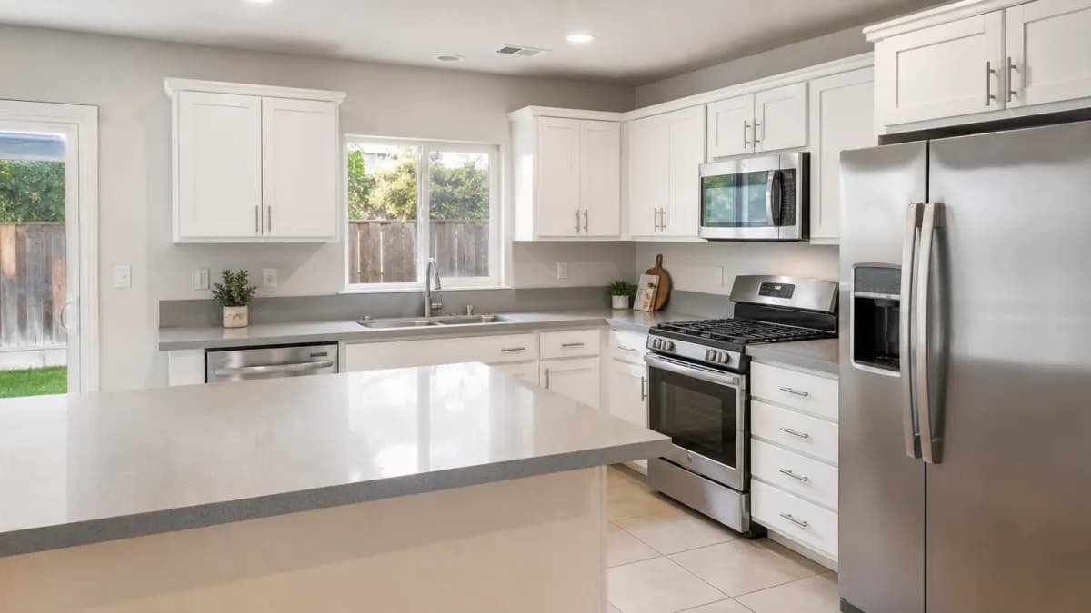 Updated kitchen in a 1990s-era valley tract home with light quartz countertops and a peninsula